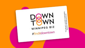 A bright orange background with bright pink dots. The Downtown Winnipeg Biz Logo is seen in the middle along with the Find It Downtown hashtag.